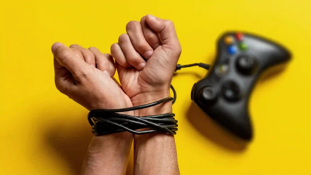 Consecuencias de la Adicción a los videojuegos, mano atada con el cable de un mando de Xbox